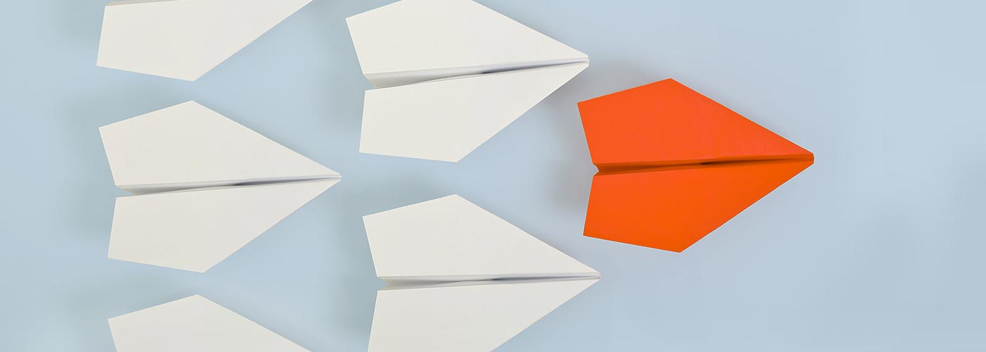 Foto di alcuni aeroplani stilizzati di carta bianchi ed arancioni