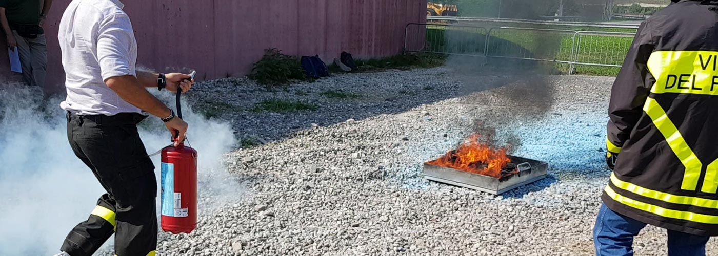 Due vigili del fuoco mostrano come spegnere un fuoco durante un corso sulla sicurezza a Bolzano